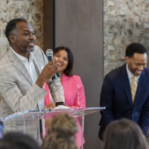 Man speaking in front of a happy audience